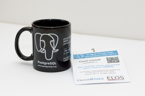 Návštěvníci dostali na památku hrnek s logem PostgreSQL a visačku s QR vizitkou a programem